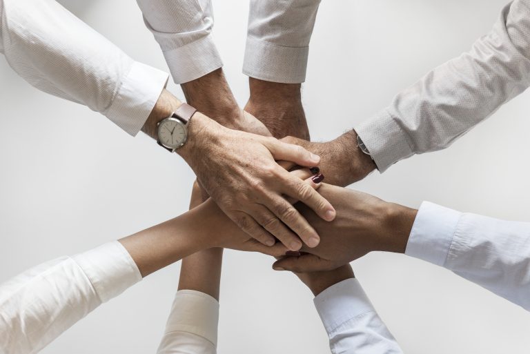 Handen op elkaar als teken van samenwerking
