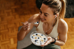 The athlete eats quark with fruit as a post-workout recovery meal
